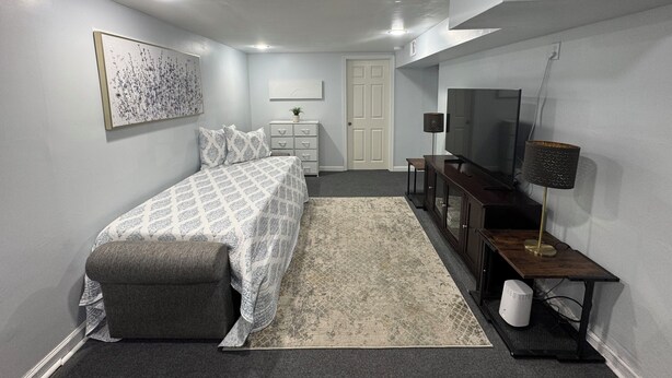 Un dormitorio con cama, escritorio, televisor y lámpara.