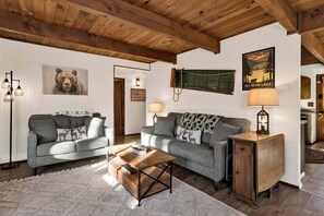 A cozy living room with two grey sofas, a wooden coffee table, and a small cabinet. - 2594-willow Bear Lodge (Big Bear Lake)