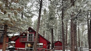 A red cabin with a balcony, surrounded by tall pine trees in a snowy forest. - 2594-willow Bear Lodge (Big Bear Lake)