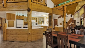 A wooden interior with a kitchen, dining area, and a staircase. - 2597-the Village Timber Lodge (Big Bear Lake)