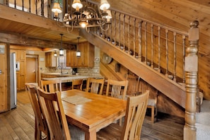 A wooden interior with a dining area, kitchen, and staircase. - 2605-crystal Pines (Big Bear Lake)