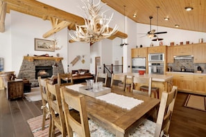 A spacious living room with a fireplace, wooden furniture, and a chandelier. - 2606-view on the Rocks (Big Bear Lake)