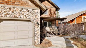 A house with a stone facade, a garage, and a wooden deck. - Brownie Resort #2618 (Big Bear Lake)