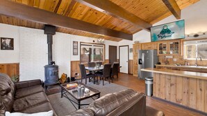 A cabin interior with a dining area, kitchen, and living room. - 2655 - Highland Hideout (Big Bear Lake)
