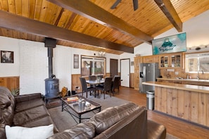 A cabin interior with a living room, dining area, and kitchen. - 2655 - Highland Hideout (Big Bear Lake)
