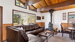 A cozy living room with a leather sofa, a coffee table, and a fireplace. - 2655 - Highland Hideout (Big Bear Lake)