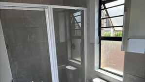 A modern bathroom with a shower, toilet, and sink. - Charming 3-bedroom House Rental in Centurion, South Africa (Centurion)