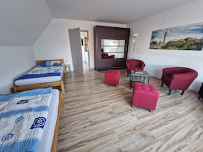 Ein modernes Schlafzimmer mit einem hölzernen Bett, einem roten Sessel, einem kleinen Tisch und einem Gemälde an der Wand.