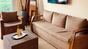 A living room with a sofa, chairs, a flat-screen TV, and a painting on the wall. - Luxury Lakeview Home with Pool • Nature Retreat for Groups in charming Granada (Granada)