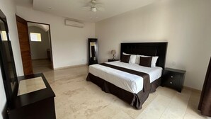 Una camera da letto con un letto, un comodino, una cassettiera, uno specchio e una ventola a soffitto.