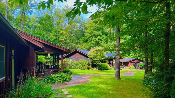 A rustic cabin with a stone pathway leading to a covered porch.