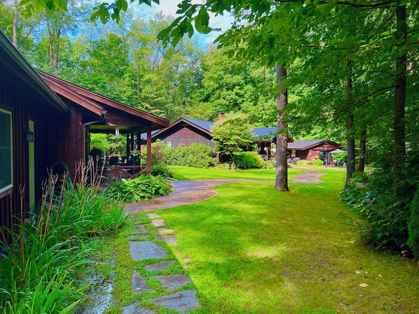 A rustic cabin with a stone pathway leading to a covered porch.