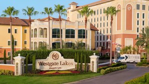 A hotel with a sign reading 'Westgate Lakes' and a large building with multiple windows and a red roof. - Orlando Studio Villa Near Disney - Westgate Lakes (Orlando)