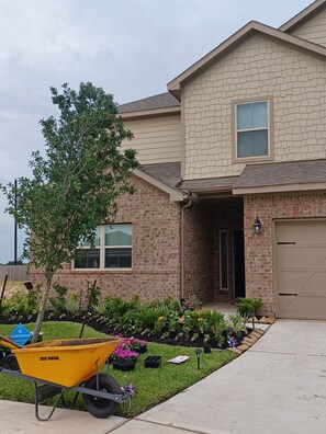 A two-story house with a brick facade, a front door, and a garage.