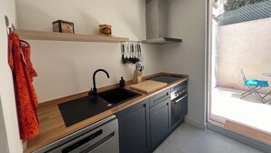 Eine moderne Küche mit Geschirrspüler, Spüle und einem Fenster zur Rechten.