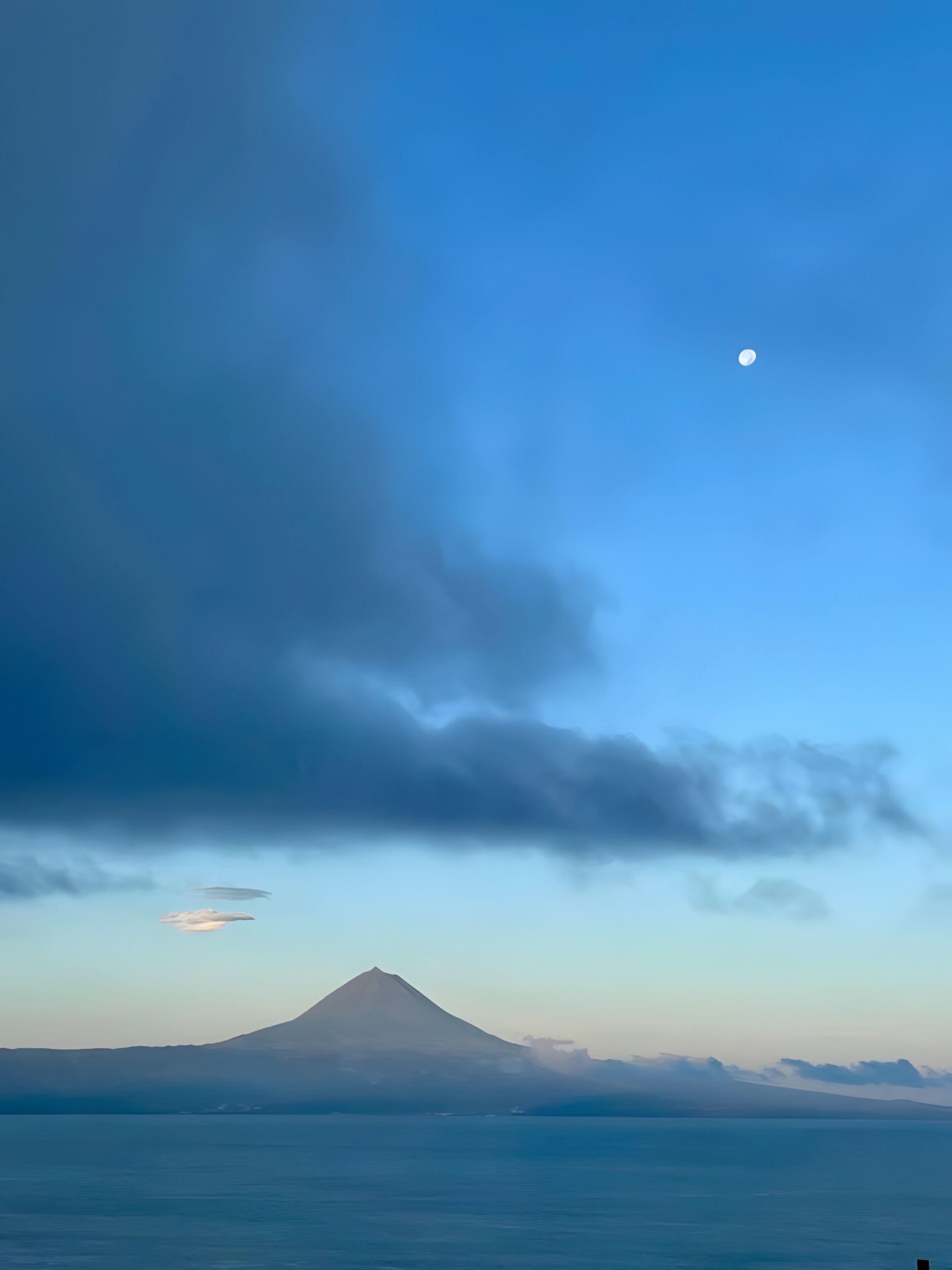 A mountain with a clear sky and a moon.