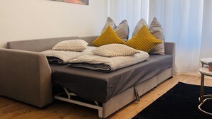 Una sala de estar moderna con un sofá, un cuadro y una ventana con cortinas.