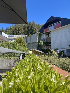 Zona residencial con edificios modernos, una estructura de madera y abundante vegetación.