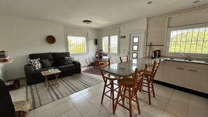 A modern kitchen with a dining area, a black sofa, and a large window with a view. - 4-bedroom house with private pool in charming Begur.. (Begur)