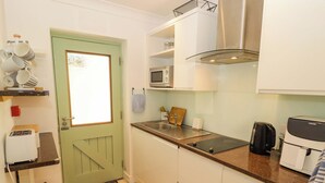 Una cocina compacta equipada con microondas, tostadora y cafetera.