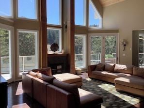 A spacious living room with large windows, a fireplace, and a cozy seating area.