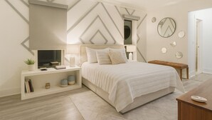 Un dormitorio moderno con cama, mesitas de noche, televisor y espejos decorativos.
