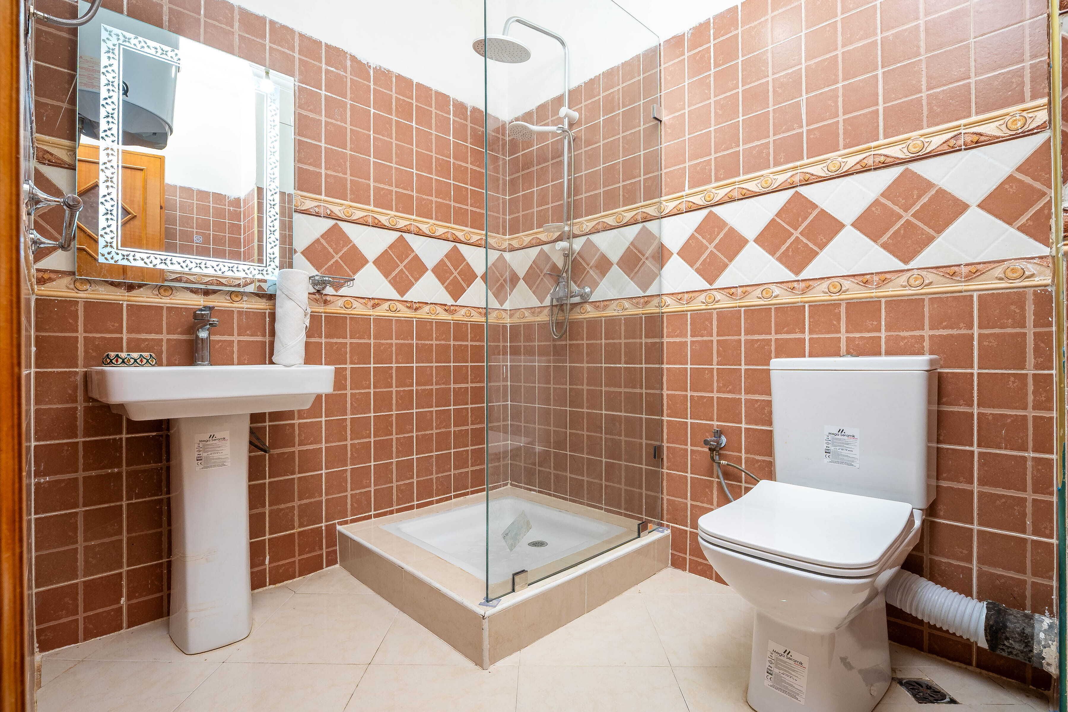 A bathroom with a shower, sink, and toilet.