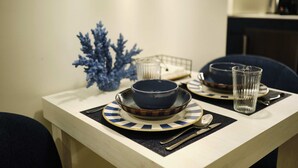 A dining table with a blue bowl, a glass, and a spoon on a placemat. - Studio Premium Suite Venezia, non-smoking (Avilés)
