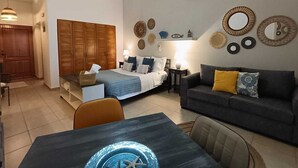 A bedroom with a bed, bedside tables, a dresser, and a nightstand. - Fastastico Apt. Al Cadaques villa and Resort (BAYAHIBE)