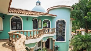 Un edificio con un balcone curvo, una cupola e un tetto in tegole.