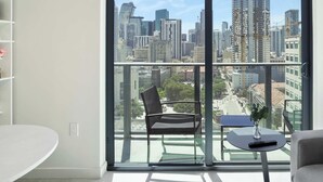 A modern apartment with a large balcony, a white round table, a black chair, and a small potted plant. - Skyline Views From 18th Floor, Pool & Workspace (Miami)