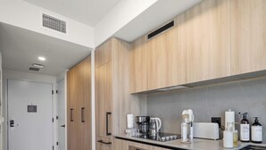 A modern kitchen with wooden cabinets, a Bosch oven, a coffee maker, and various kitchen appliances. - Skyline Views From 18th Floor, Pool & Workspace (Miami)