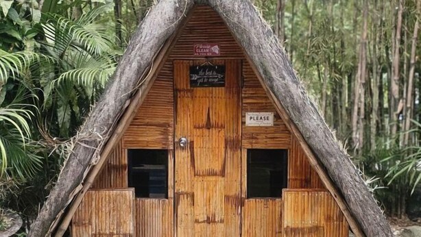 A small wooden hut with a thatched roof, a wooden door, and a sign reading 'Please clean as you go.' - Soulelle Villa with Pool (Silang)