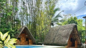 Two thatched-roof cabins with a swimming pool in between. - Soulelle Villa with Pool (Silang)