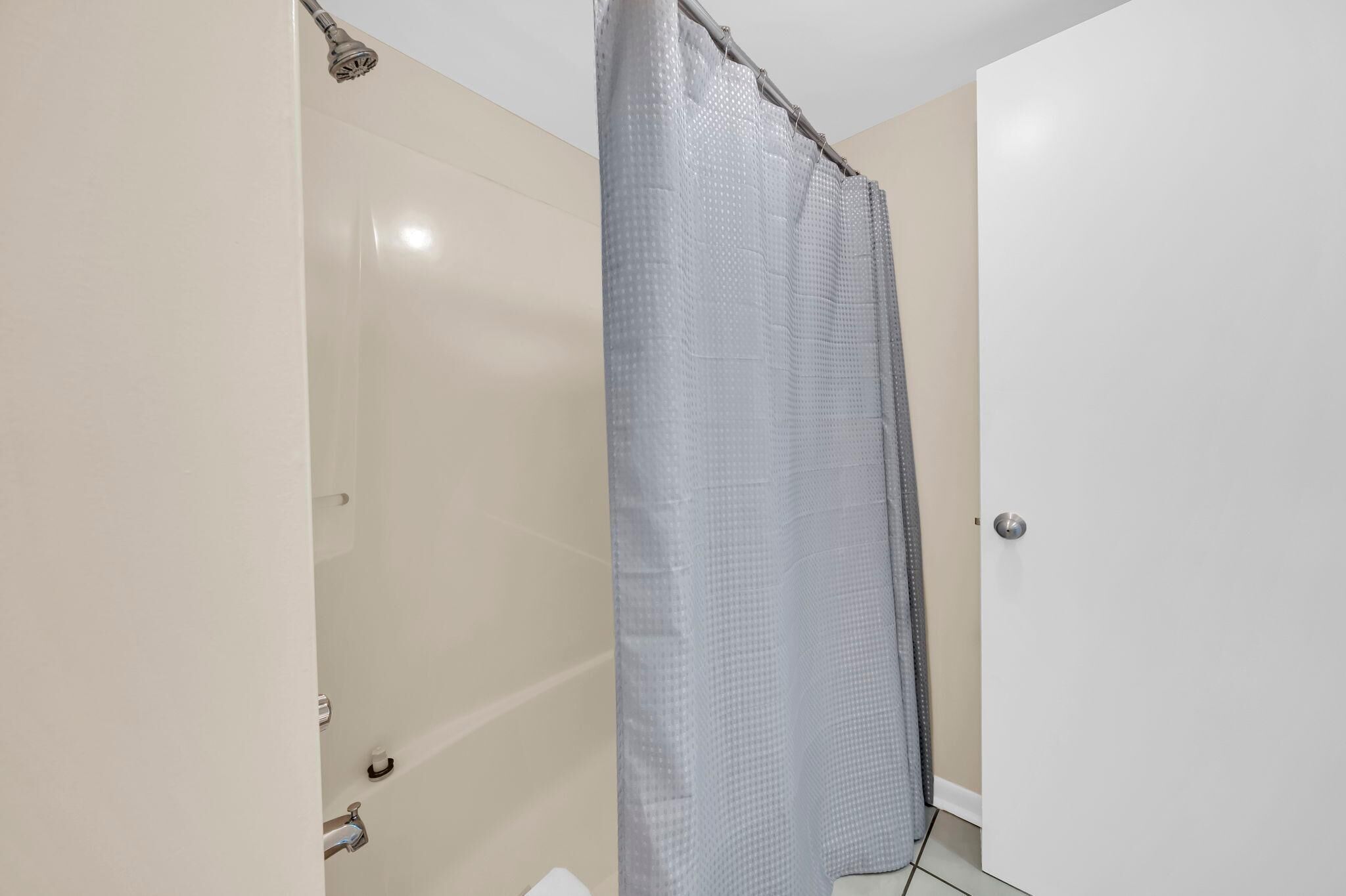 Un baño con cortina de ducha, inodoro y lavamanos.