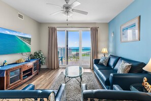 A living room with a TV, sofa, and a balcony with a view. - Ariel Dunes II 1507 (Miramar Beach)