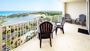 A balcony with chairs, a view of a lake, and buildings in the background. - Ariel Dunes II 1507 (Miramar Beach)