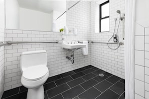 Uma casa de banho moderna com sanita branca, lavatório e zona de duche.