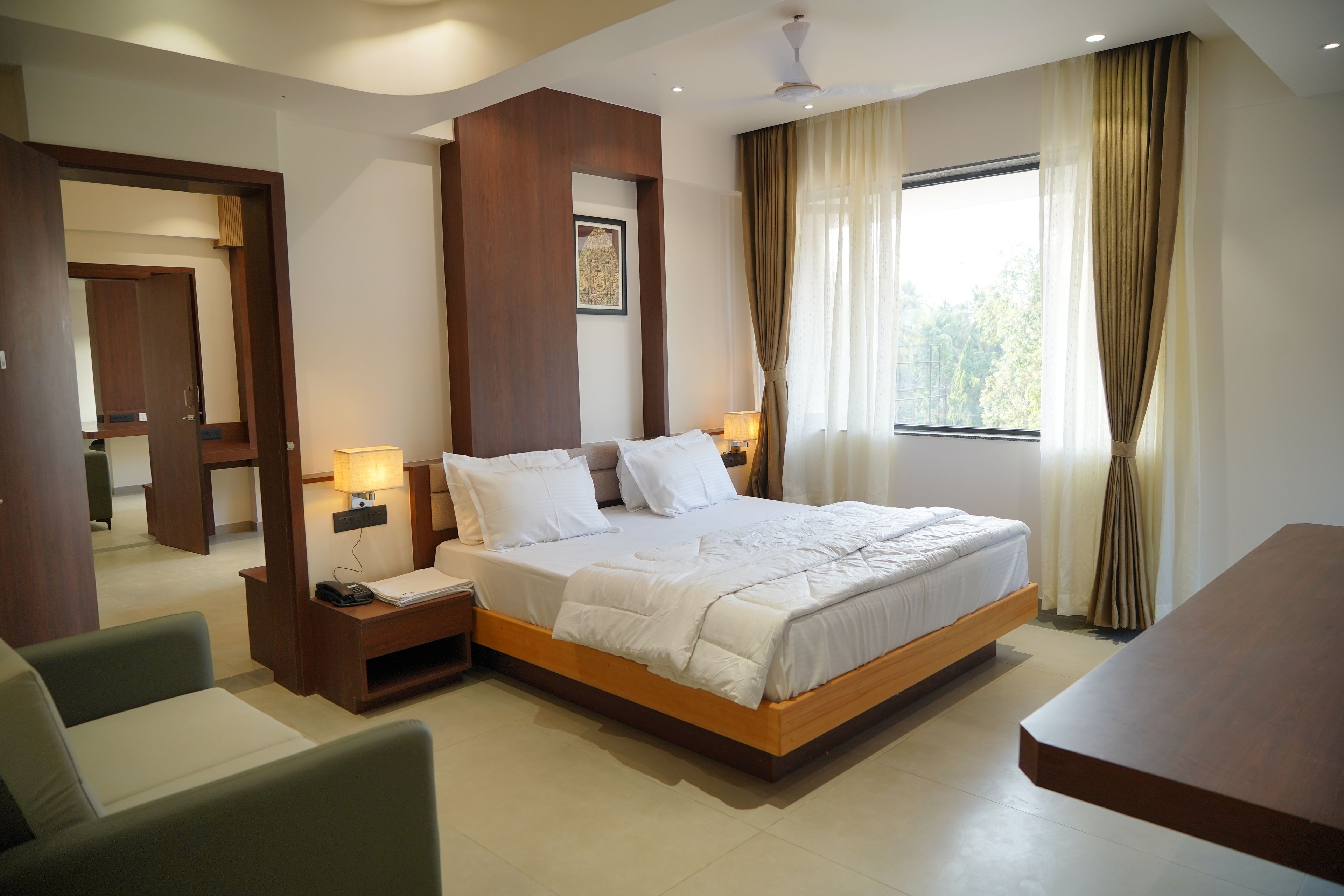 A hotel room with a large bed, bedside tables, a desk, and a chair.
