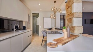 A modern kitchen with a central island, a built-in oven, and a pendant light. - Superb duplex in the center of Paris (Paris)