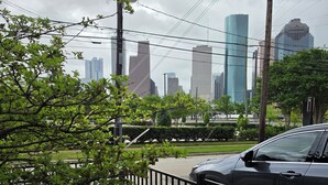 Une vue urbaine avec des bâtiments modernes, une voiture et une clôture.