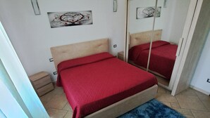 Un dormitorio con una cama, un espejo y una alfombra azul.