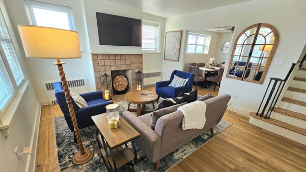 Una sala de estar con chimenea, un comedor y una escalera.