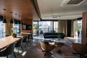A modern living room with a dining area, large windows, and a balcony. - HIT Itaim (São Paulo)