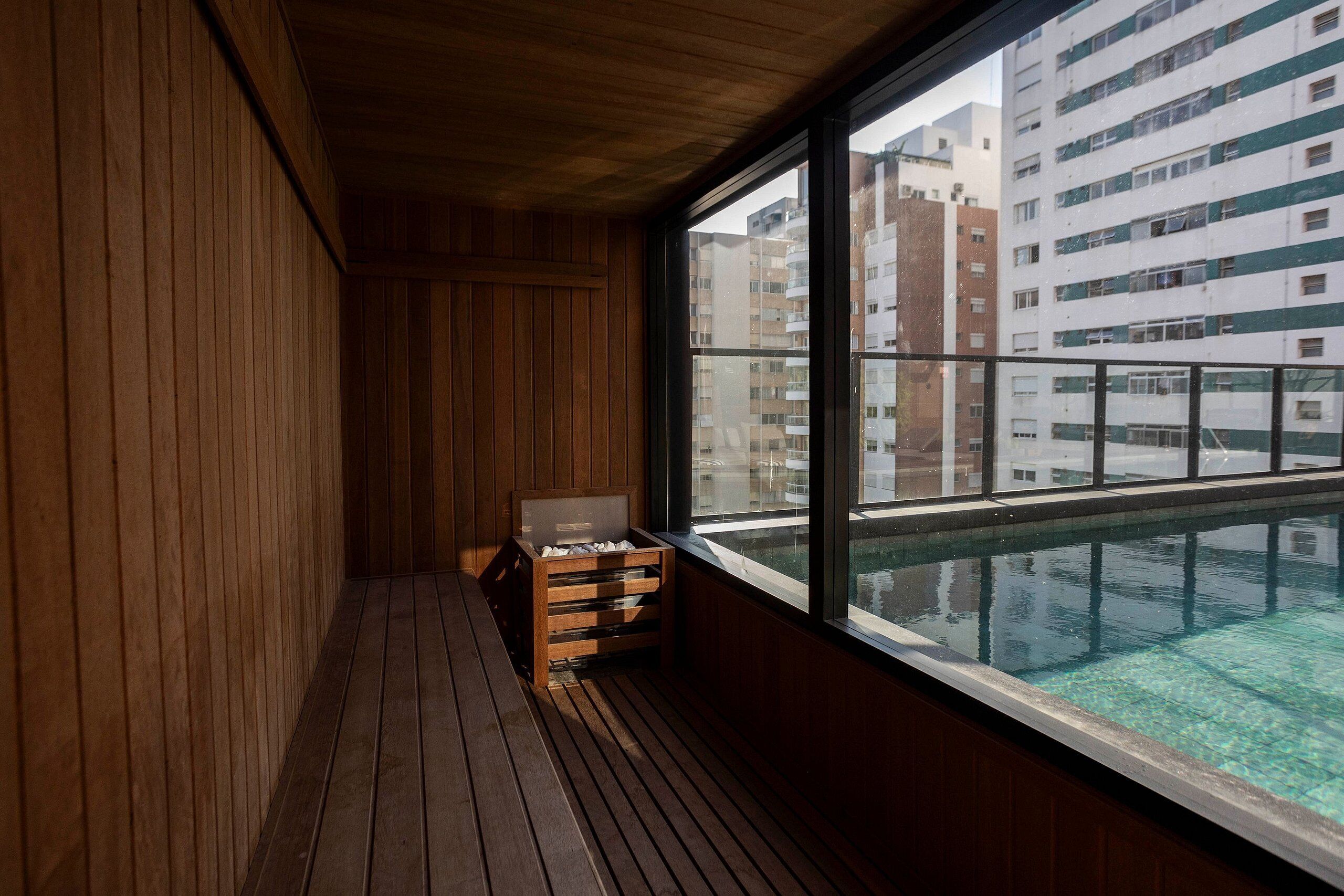 A wooden interior with a large window overlooking a swimming pool.