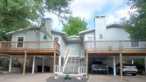 A two-story house with a covered driveway and a garage. - Soothing 3-bedroom house with AC in vibrant Austin near downtown! (Austin)
