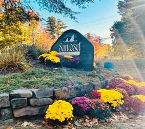 A sign with the name 'Samoset' in a stylized font, surrounded by colorful flower beds.