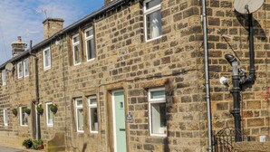 A stone building with multiple windows, a door, and a satellite dish. - Vasey Croft (Keighley)