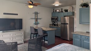 A compact kitchen with a TV, dining area, and a ceiling fan. - Parkside Suite: Downtown Jacksonville (Jacksonville)
