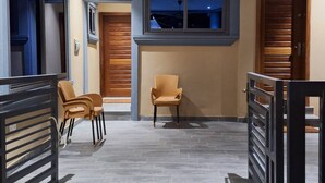 Un intérieur moderne avec un ventilateur de plafond, une fenêtre offrant une belle vue et un coin salon avec des fauteuils.